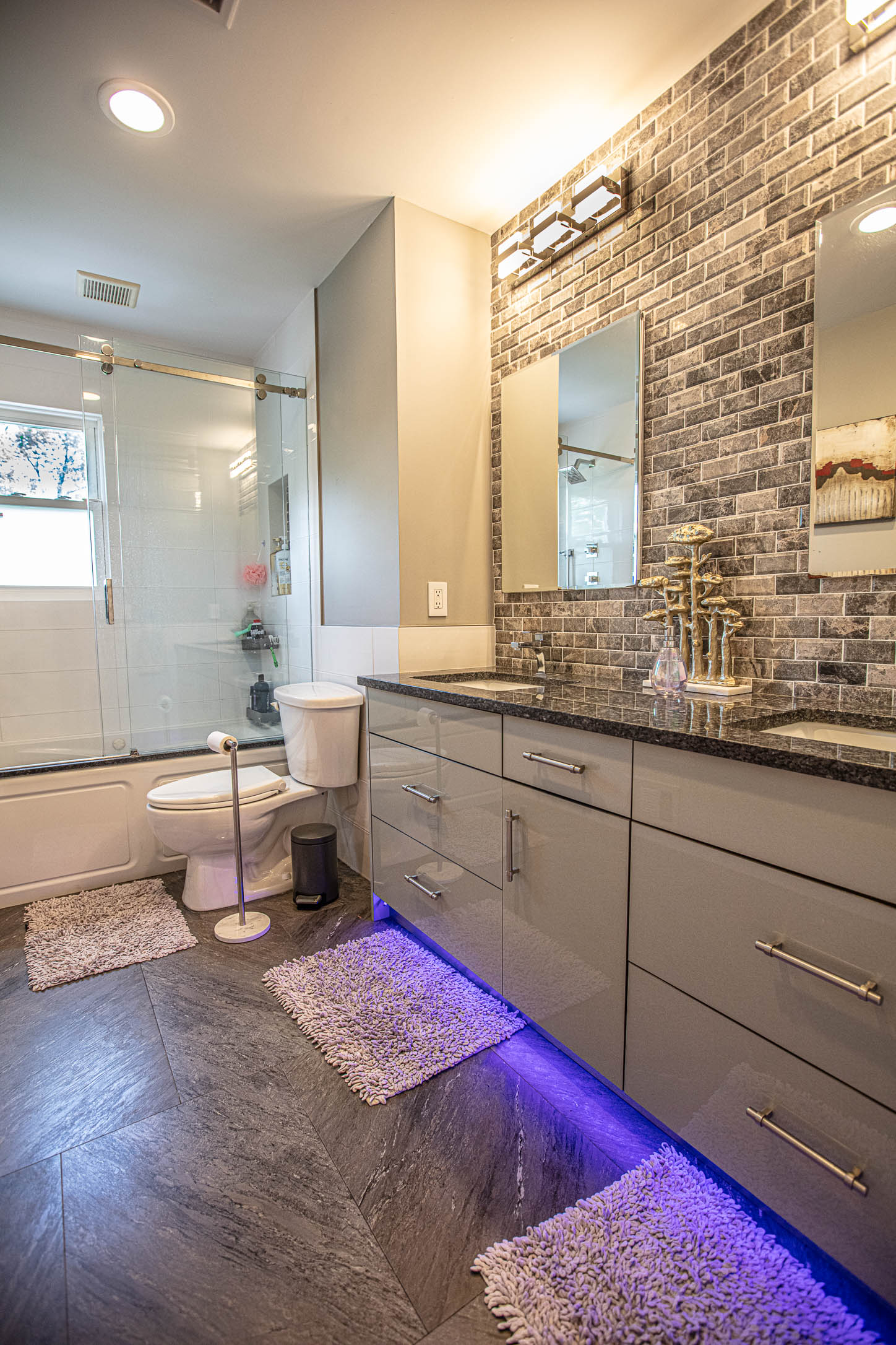 Marble Manhattan bathroom with frameless glass shower, wall-hung fixtures, and floating vanity
